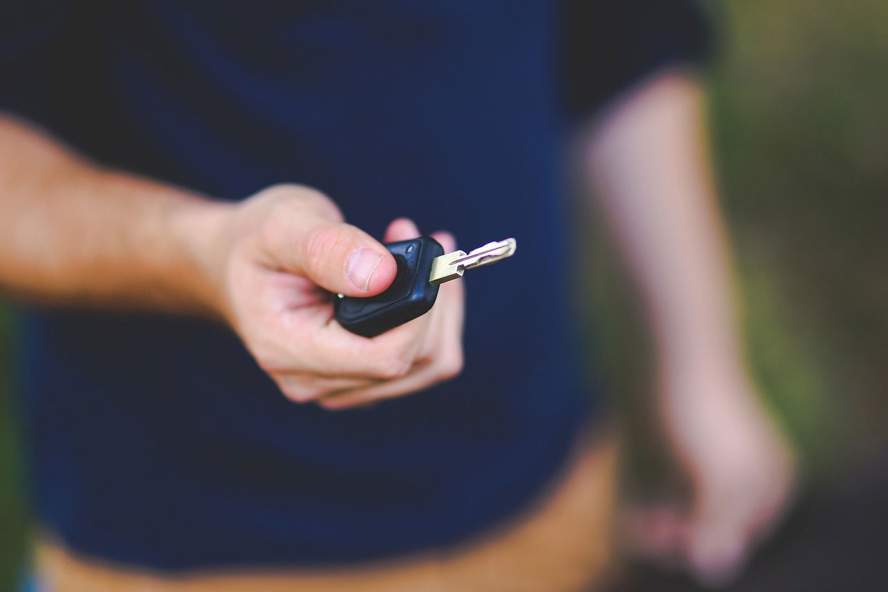 photo of car key handled by people